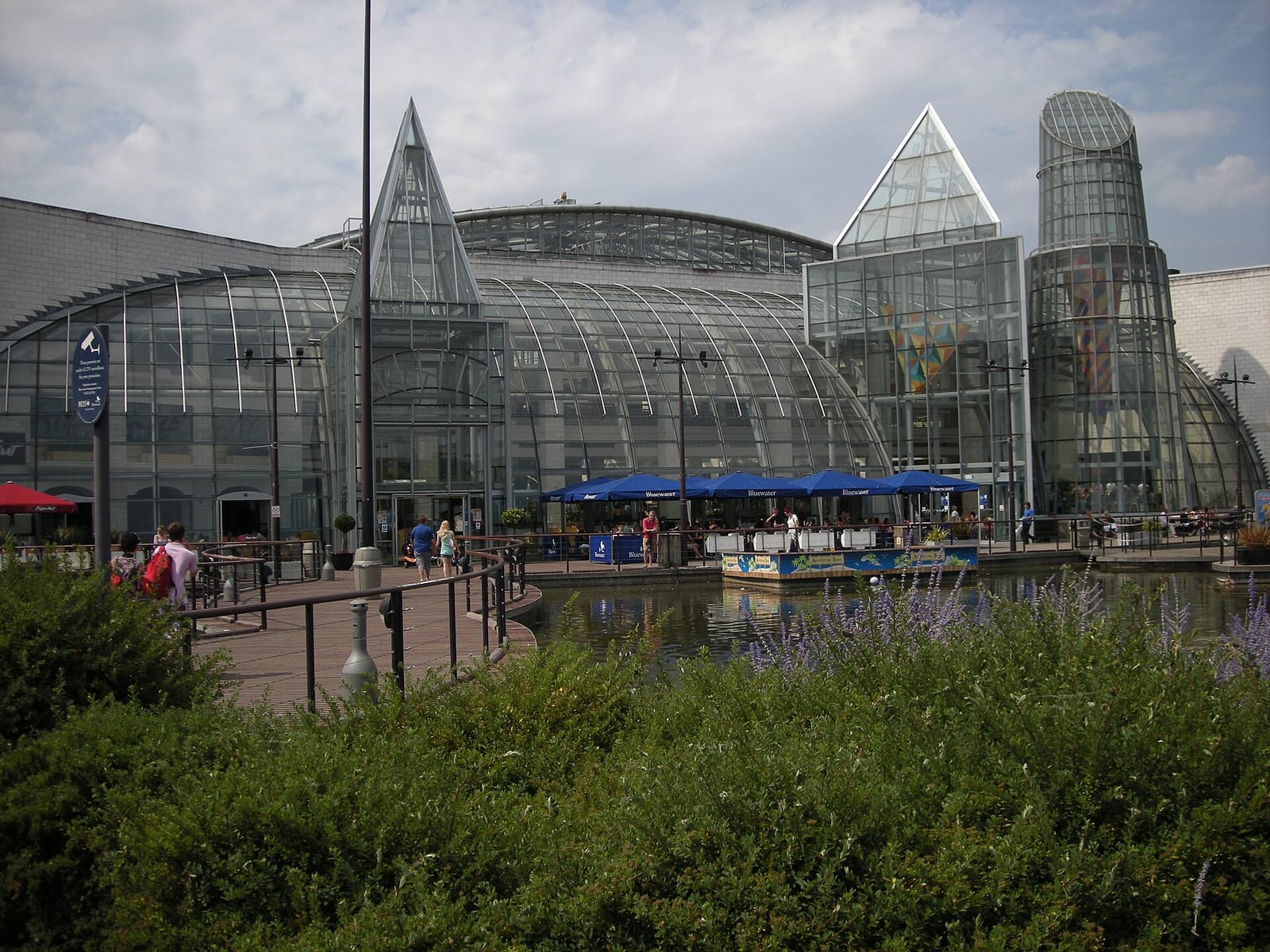 The glazed exterior of the Bluewater shopping centre near Greenhithe, seen across its lake.