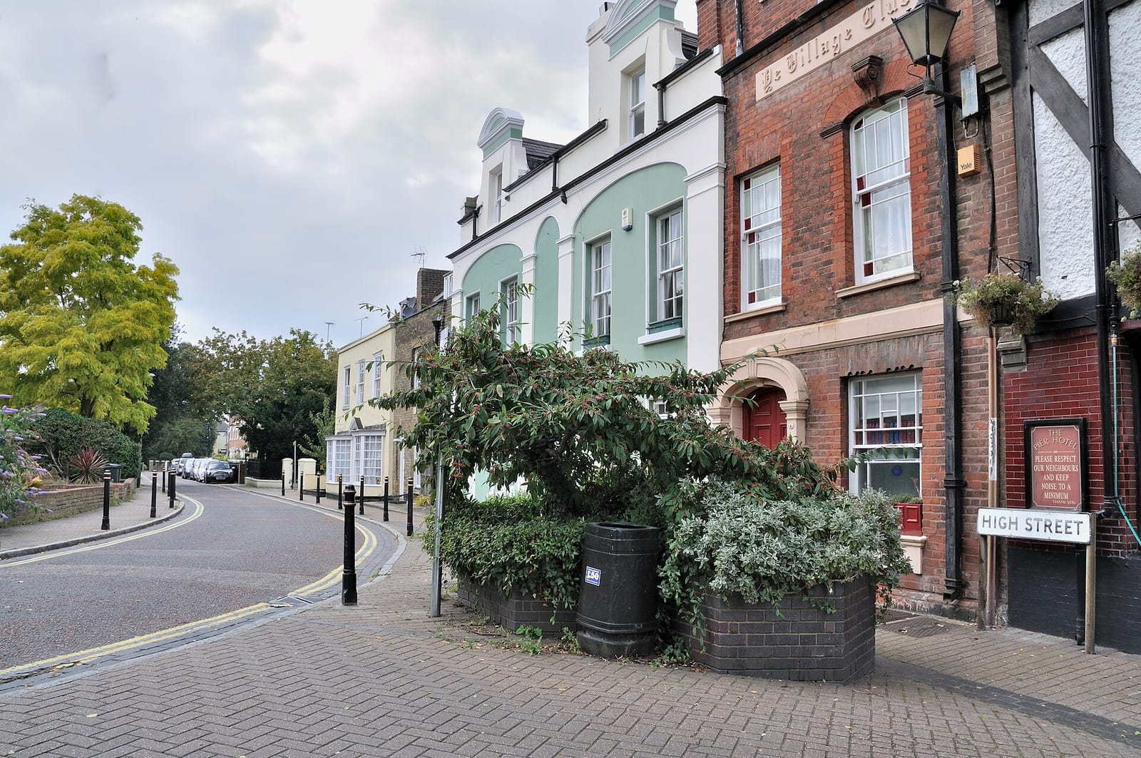 Greenhithe High Street in Kent, a mix of brick and painted houses on the bend running down towards the River Thames.